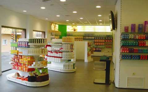 gondolas centrales con estantes redondeados y murales de estanteria con cajones para farmacia