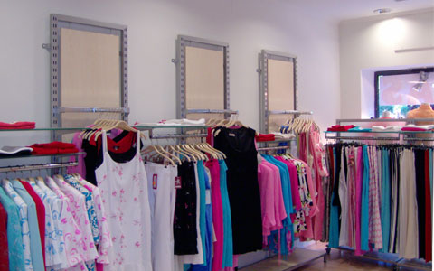 Vista de un comercio de ropa con mobiliario comercial de la serie 4200 con marcos a pared y fondos de madera