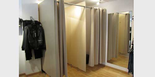 probadores para tienda de confeccion con ñaterales de madera y barras para cortinas